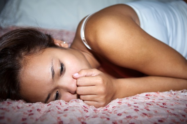 Girl lying on the bed, looking sad. Shallow DOF.